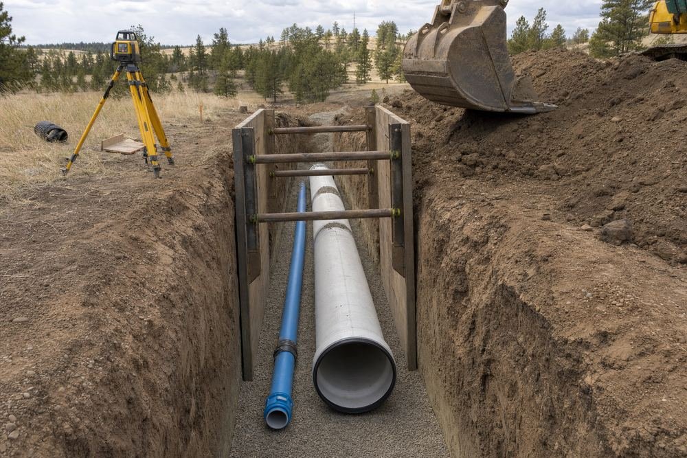 Excavated trench with new sewer and water line ready for backfill
